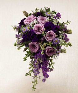 Lavender roses are offset by purple larkspur, purple double lisianthus, lavender monte casino asters and Queen Anne's Lace to create a fantastic display of floral beauty and elegance. Approx. 20”H x 10”W