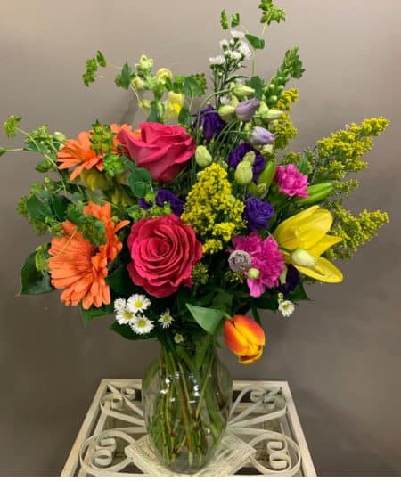 With this rather exceptional arrangement of bright red, yellow, and purple flowers, you can show that special someone just how much they really count. Alstroemeria and Roses blend with Chrysanthemums, Gerberas, and Snapdragons in a glass vase. Approx. 22" W x 29" H.
