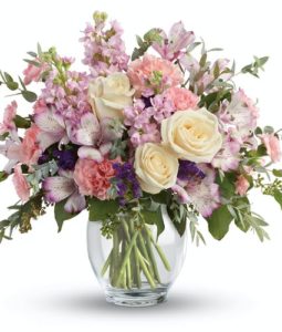 This pretty arrangement includes lavender alstroemeria, pink carnations, miniature pink carnations, pink stock, purple sinuata statice, parvifolia eucalyptus, and seeded eucalyptus. Delivered in a Clear Glass Ginger Jar. Approximately 14 1/2" W x 13 1/2" H