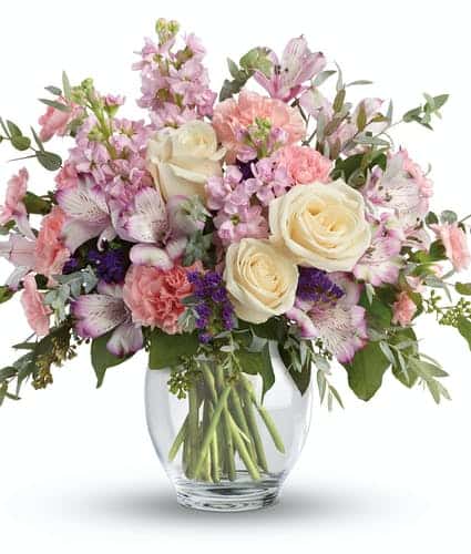 This pretty arrangement includes lavender alstroemeria, pink carnations, miniature pink carnations, pink stock, purple sinuata statice, parvifolia eucalyptus, and seeded eucalyptus. Delivered in a Clear Glass Ginger Jar. Approximately 14 1/2" W x 13 1/2" H