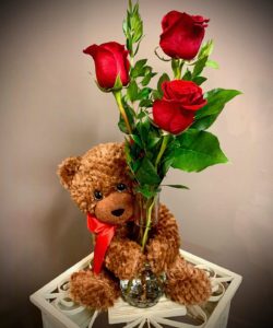 Three sweet roses in a glass bud vase arrive with a soft, plush bear